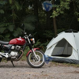 Мотоцикл припаркован у палатки в кемпинге в лесу.