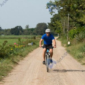 Байкер на грунтовой дороге пересекает небольшой брод.