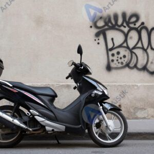 Мотоцикл припаркован у уличной стены с граффити.