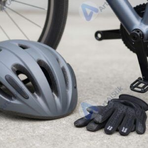 Велосипедный шлем и перчатки лежат рядом с рамой велосипеда.
