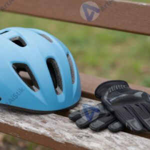 Велосипедный шлем и перчатки лежат на скамейке в парке.