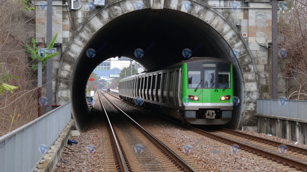 Рельсы и подъезжающий поезд метро в тоннеле. Рельсы и подъезжающий поезд метро в тоннеле.