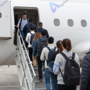 Пассажиры стоят в очереди на посадку в самолёт у выхода.