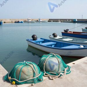 Рыбацкий порт с небольшими лодками и сетями на пирсе.