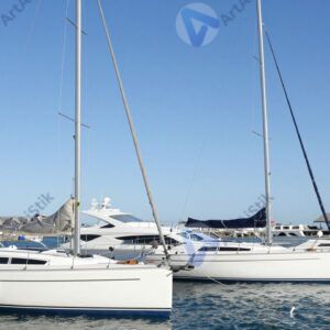 Несколько яхт с опущенными парусами стоят в марине.