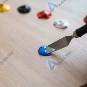 Художник смешивает краски мастихином на палитре