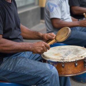 Уличный барабанщик играет на вёдрах и металлических баках.