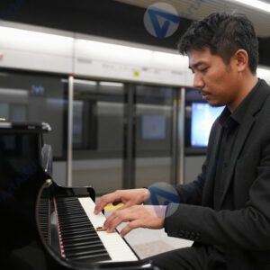 Музыкант на уличном пианино на вокзале или станции метро.