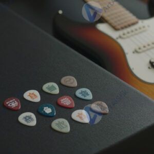 Набор медиаторов на столе рядом с электрогитарой.