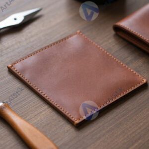 Стол с кусочками кожи и инструментами для изготовления кошельков.