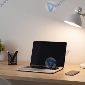 Домашний рабочий уголок с ноутбуком и настольной лампой.