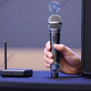 Оратор на сцене с беспроводным микрофоном и кликером в руке.