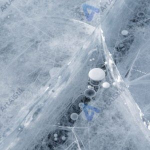 Поверхность льда с трещинами и пузырьками внутри.