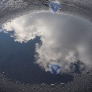 Лужа после дождя с отражением неба и облаков.